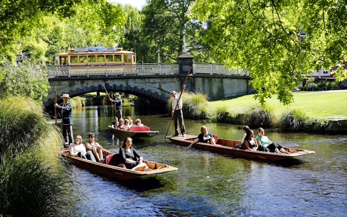Punting ride on Avon River with people enjoying the view, Christchurch.