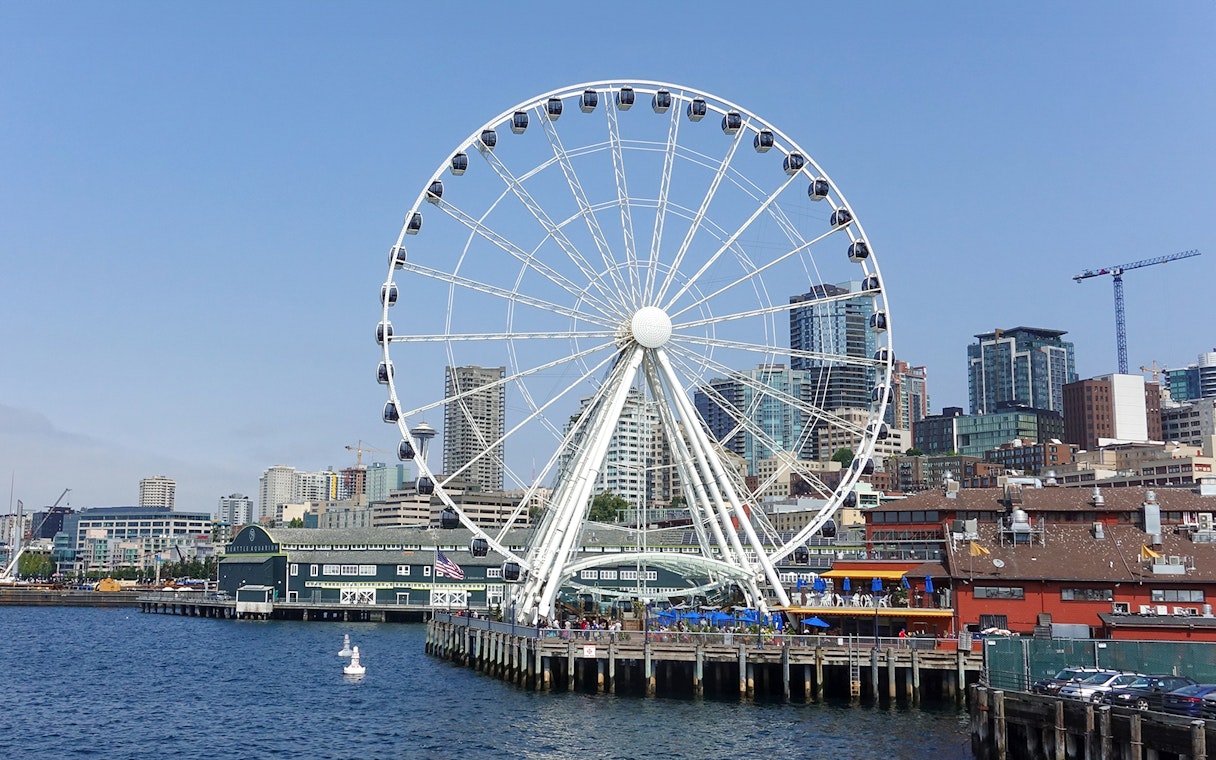 Seattle Great Wheel on waterfront with city skyline in background.