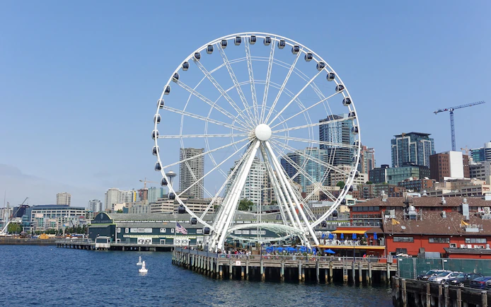 Seattle Great Wheel on waterfront with city skyline in background.