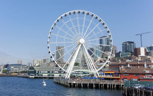 Seattle Great Wheel on waterfront with city skyline in background.