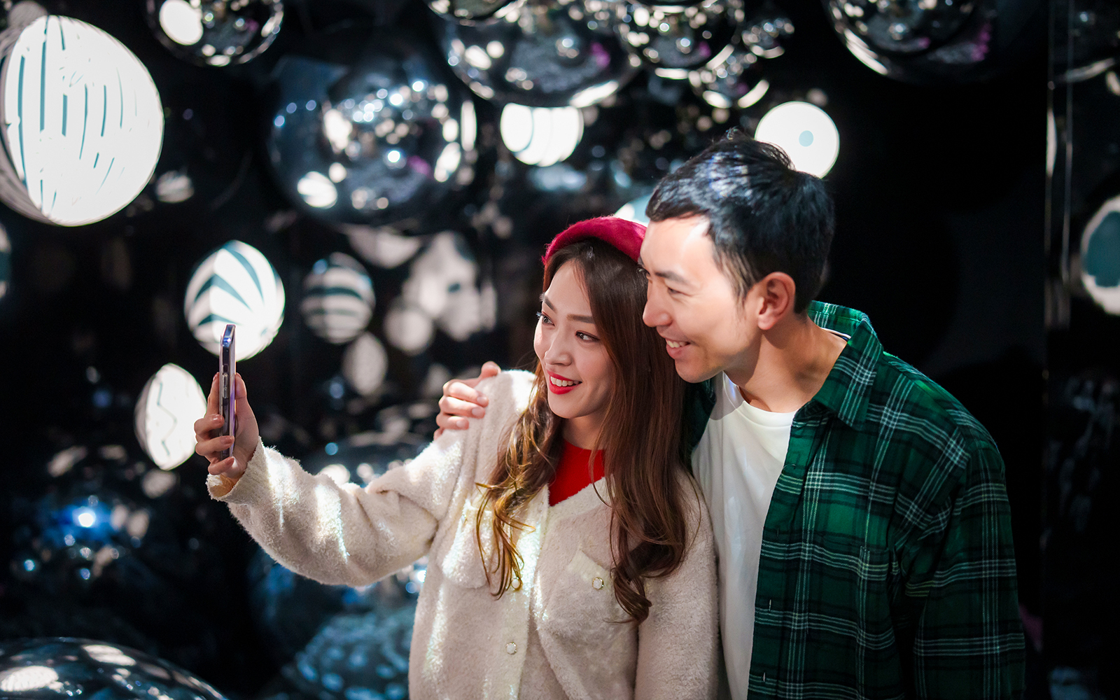 Couple taking a selfie at Ocean Park Hong Kong with reflective decor in the background.
