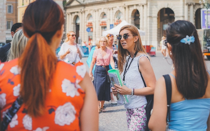 Guide leading tourists near Verona Arena, Italy.
