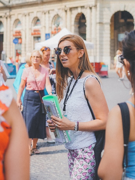 Guide leading tourists near Verona Arena, Italy.