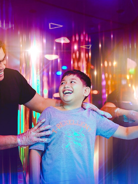 Tourists enjoying a colorful mirror maze experience.