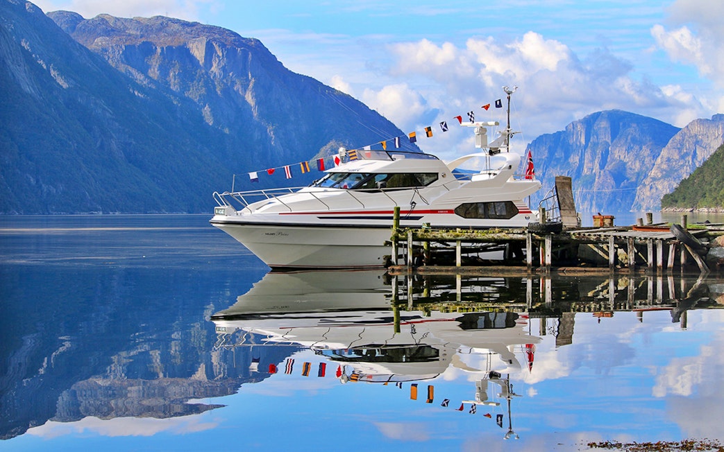 Fjord cruise boat docked at Lysefjord with mountains in the background.