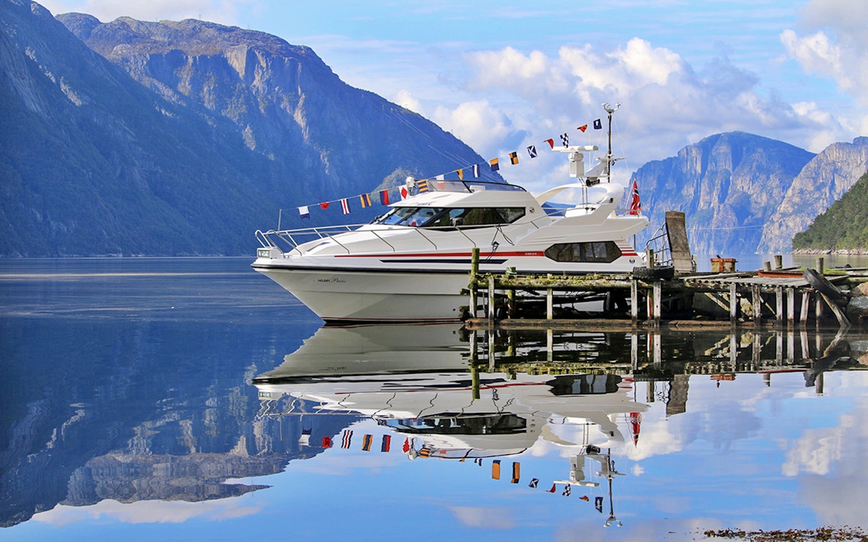 Fjord cruise boat docked at Lysefjord with mountains in the background.