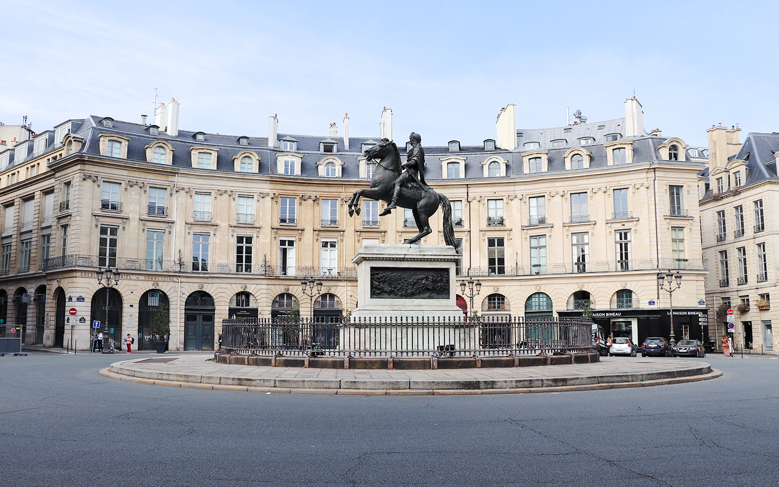 Equestrian statue at Place des Victoires, Paris, surrounded by historic buildings.