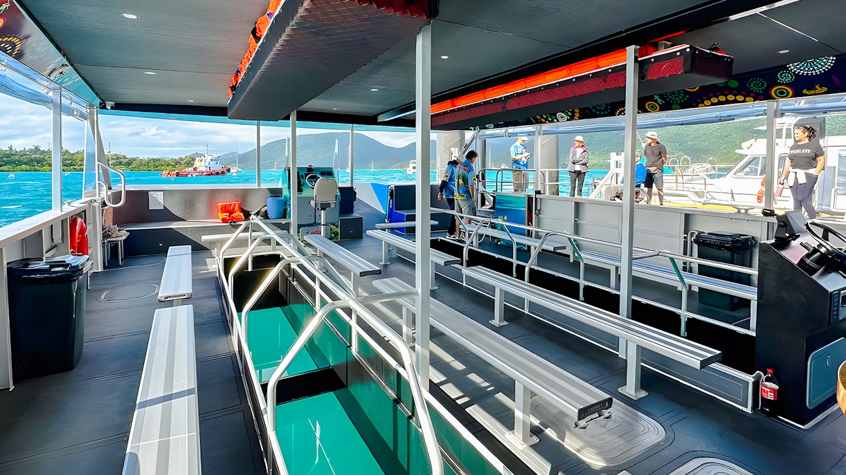 Glass bottom boat interior at Airlie Beach with passengers boarding.