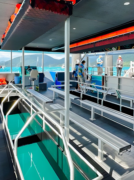 Glass bottom boat interior at Airlie Beach with passengers boarding.