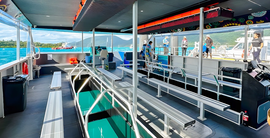 Glass bottom boat interior at Airlie Beach with passengers boarding.