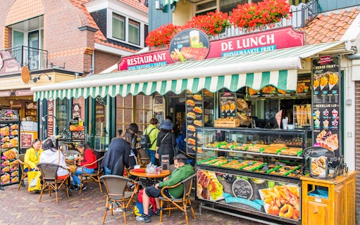 Outdoor café in Amsterdam serving traditional Dutch lunch with people dining.