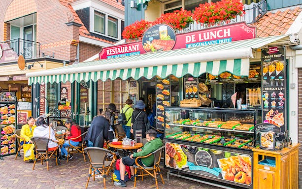 Outdoor café in Amsterdam serving traditional Dutch lunch with people dining.