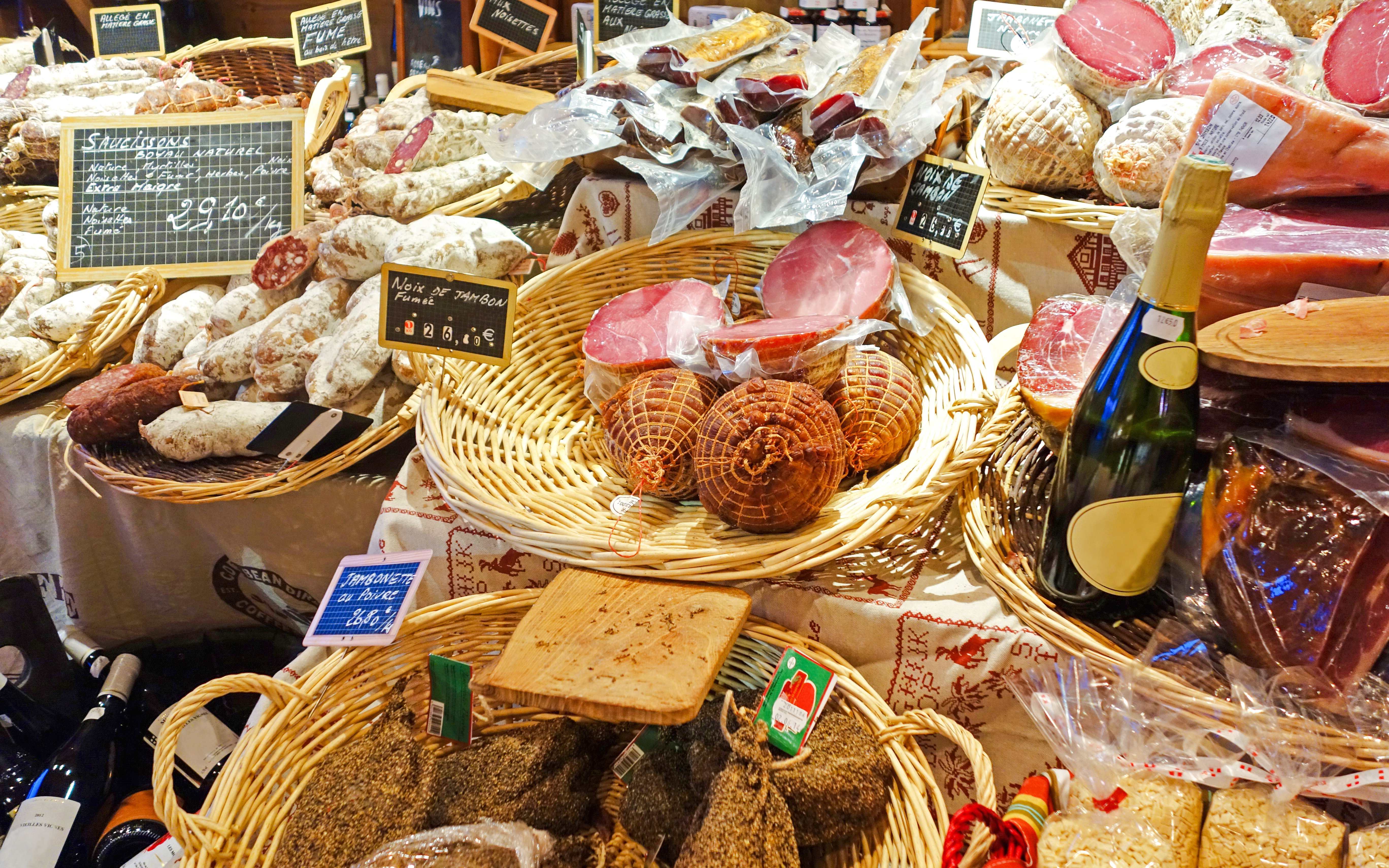 Assorted local meats and cider bottles at a Mont Saint Michel market.
