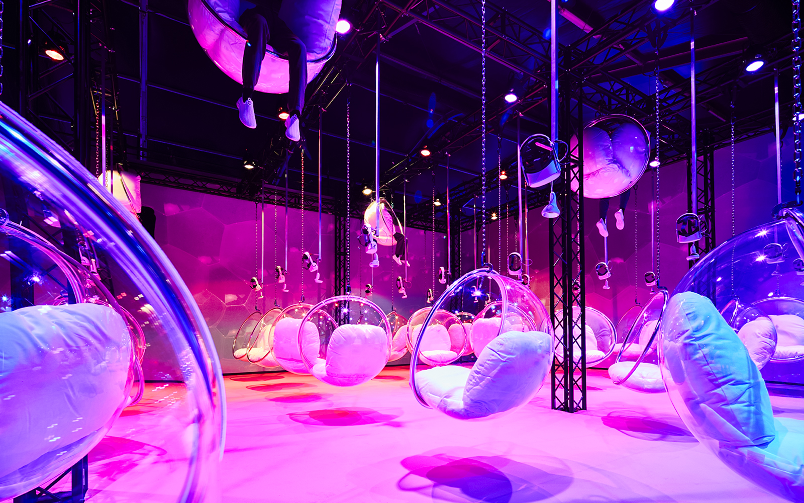Bubble chairs suspended in a vibrant, colorful room at Bubble Planet, Washington DC.