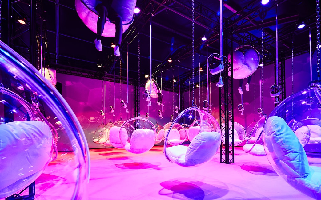 Bubble chairs suspended in a vibrant, colorful room at Bubble Planet, Washington DC.