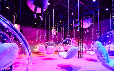 Bubble chairs suspended in a vibrant, colorful room at Bubble Planet, Washington DC.