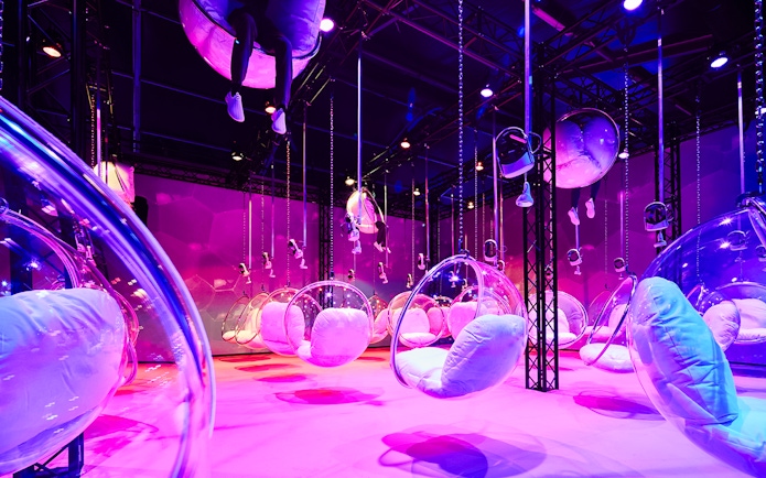 Bubble chairs suspended in a vibrant, colorful room at Bubble Planet, Washington DC.