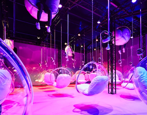 Bubble chairs suspended in a vibrant, colorful room at Bubble Planet, Washington DC.