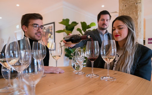 Wine tasting session at The Wine School workshop, with participants sampling red and white wines.