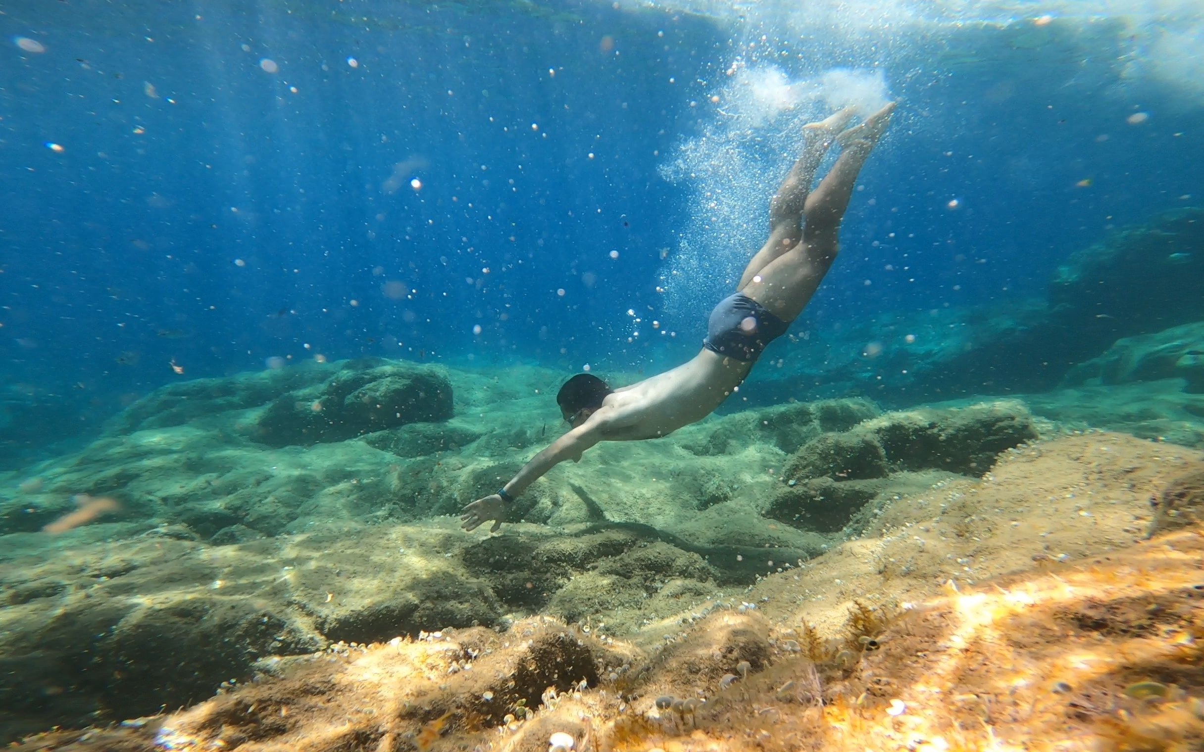 Young man snorkeling over rocky seabed in Costa Brava.