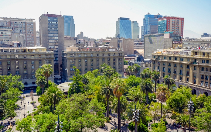 View of Santiago cityscape with palm trees and historic buildings from the Cathedral Bell Tower.