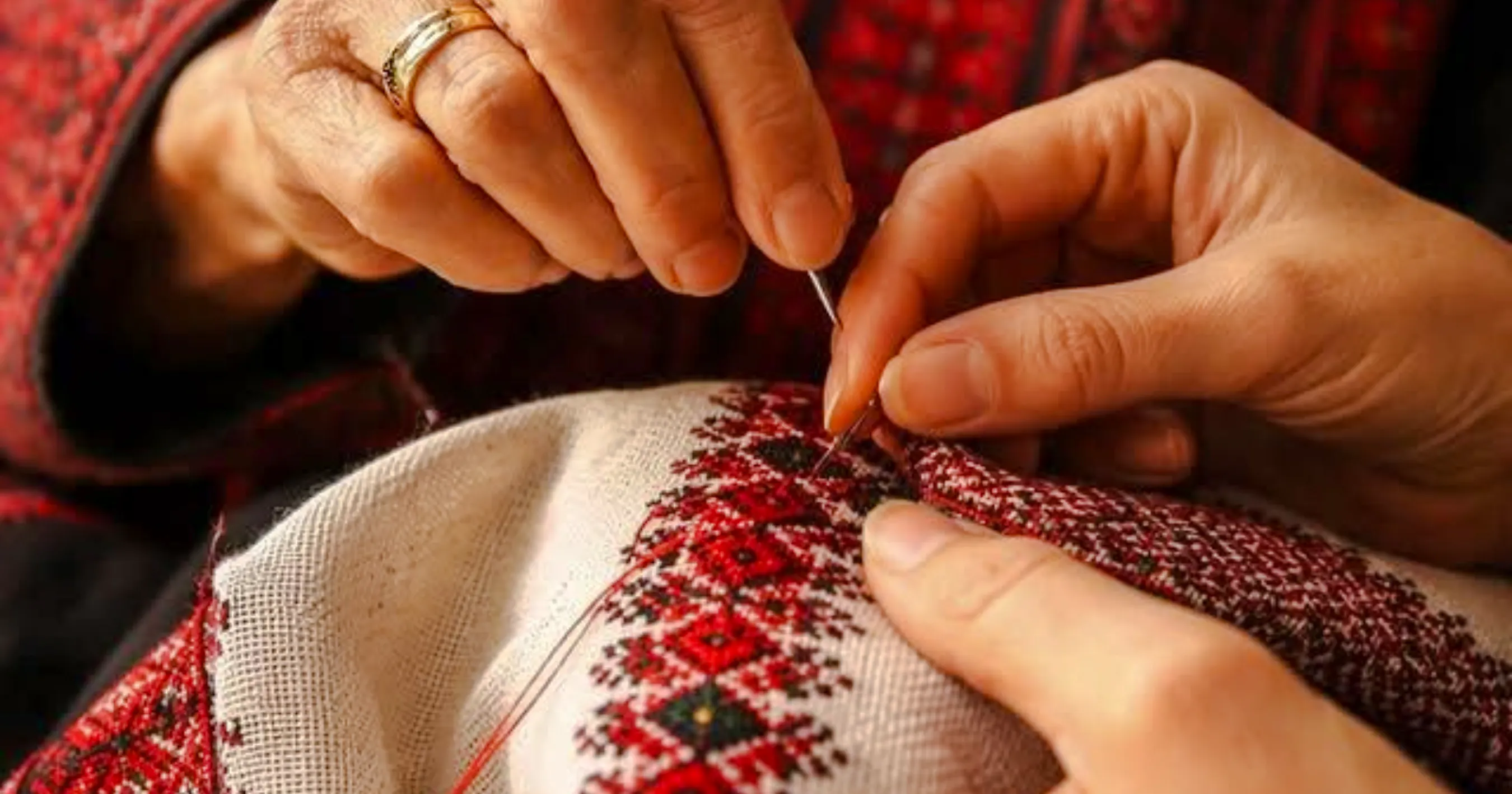 Hands sewing traditional Moroccan embroidery at a workshop in Marrakesh.
