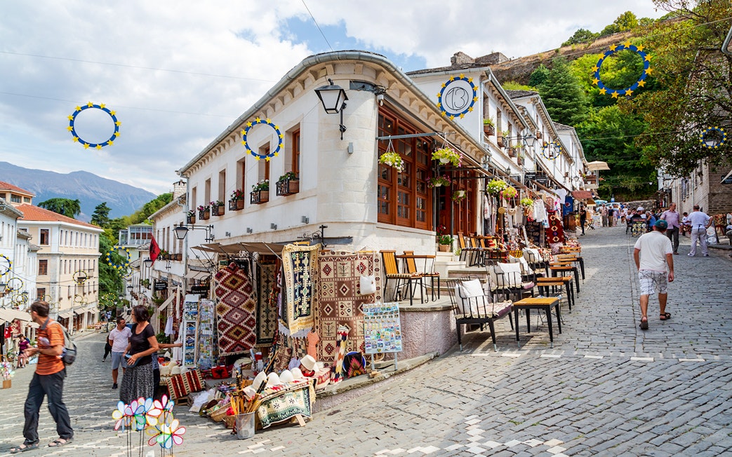 Souvenir shops lining cobblestone street in old town Gjirokaster, Albania.