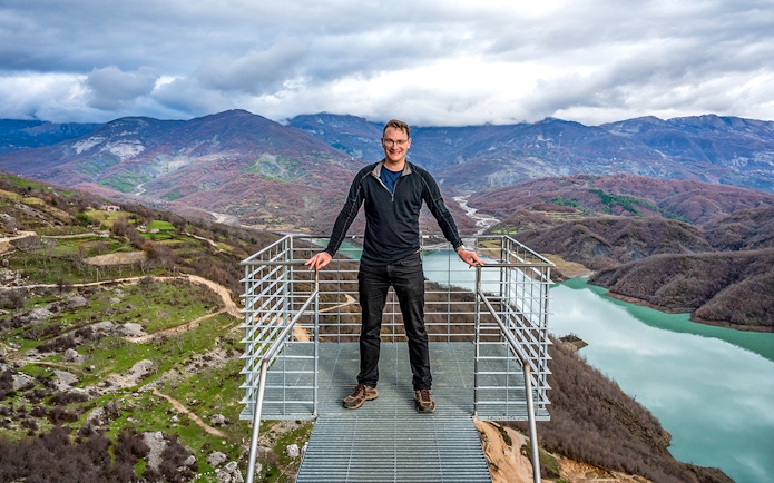 Tourist on viewing platform overlooking Gamti mountains and river.