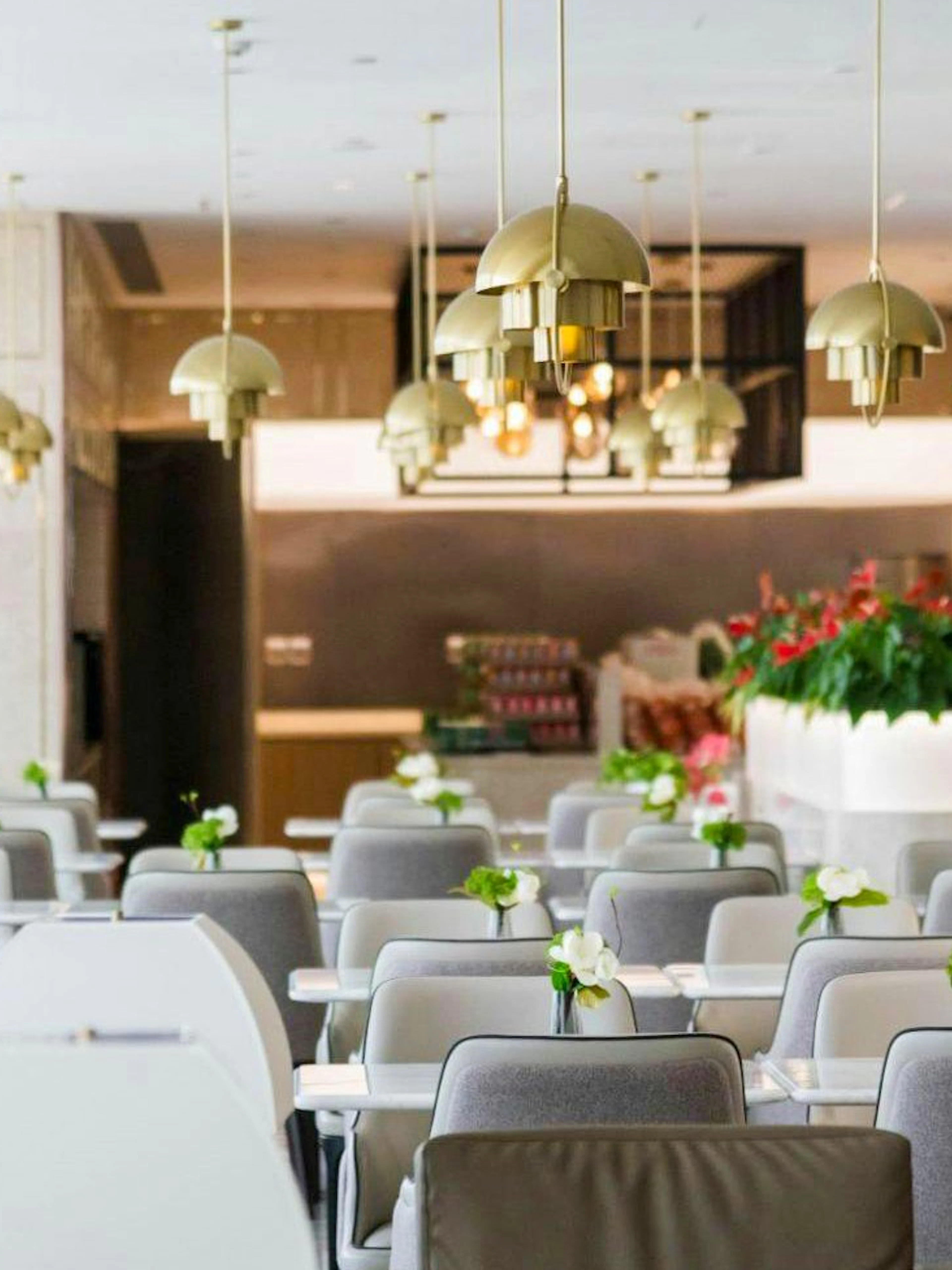 Dining area with modern lighting and floral decor at Shanghai Pudong International Airport Satellite Terminal 2.