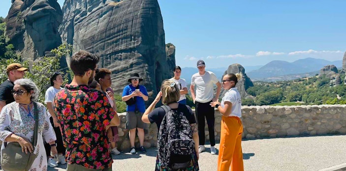 Tour group at Meteora rock formations during 1-day train trip from Athens.