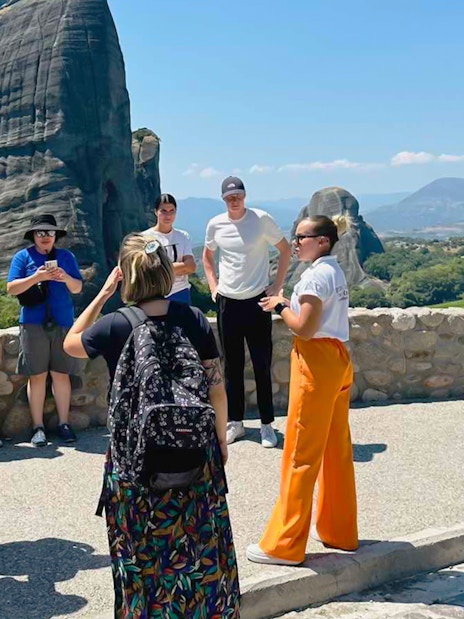 Tour group at Meteora rock formations during 1-day train trip from Athens.