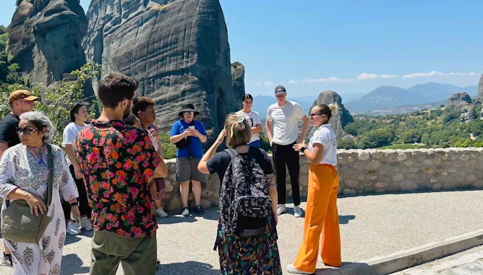 Tour group at Meteora rock formations during 1-day train trip from Athens.