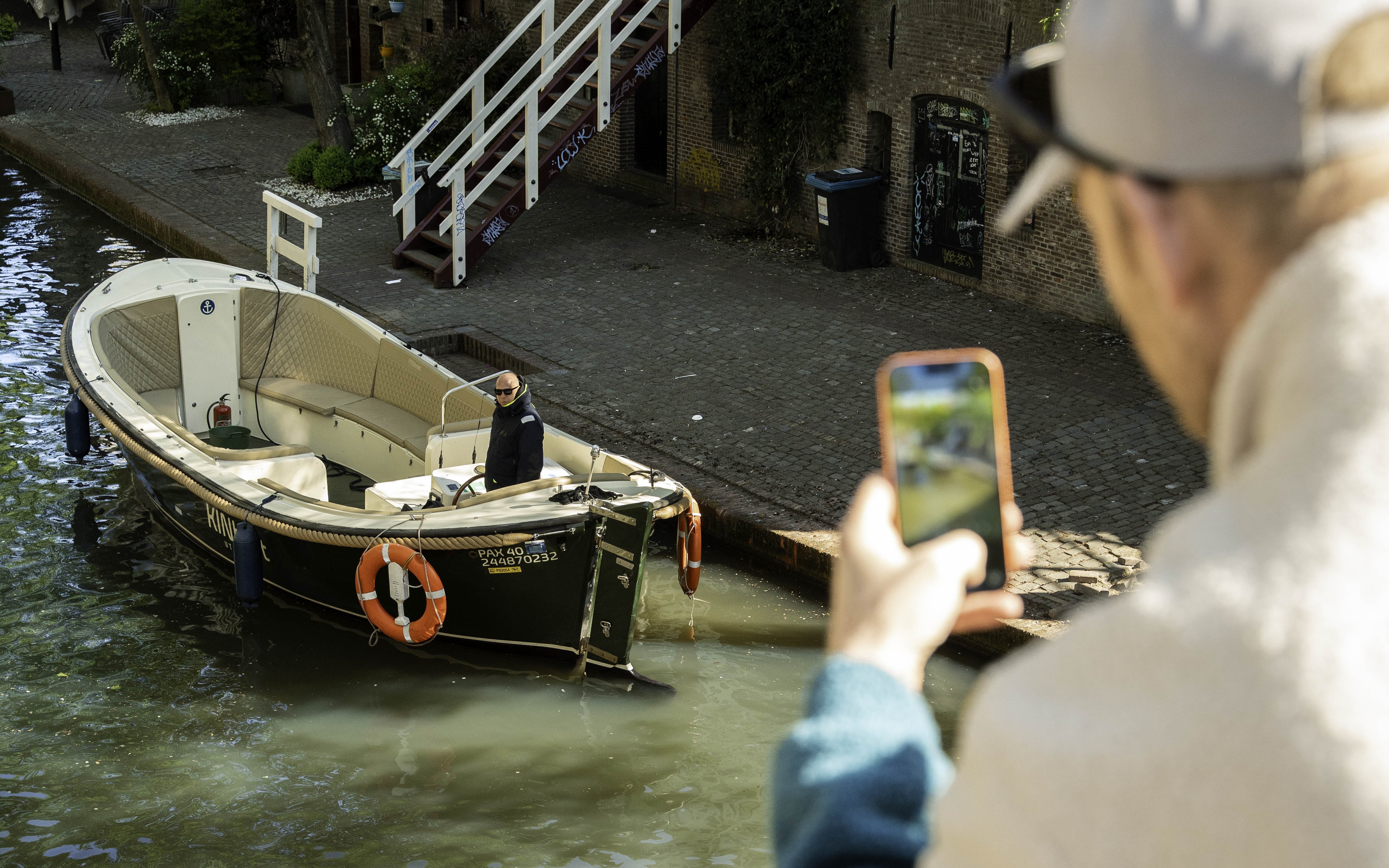 Boat tour on Utrecht canal with person taking a photo.