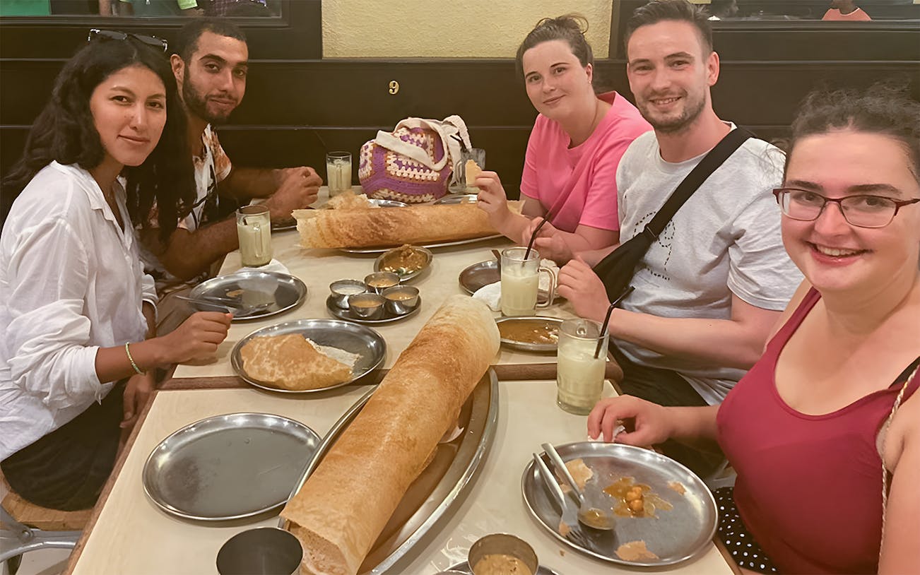 Group enjoying traditional Indian food on a 4-hour guided food tour in George Town.