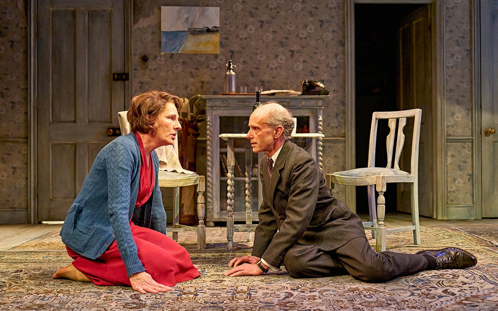 Two actors perform a dramatic scene on stage in a room setting for "The Deep Blue Sea.