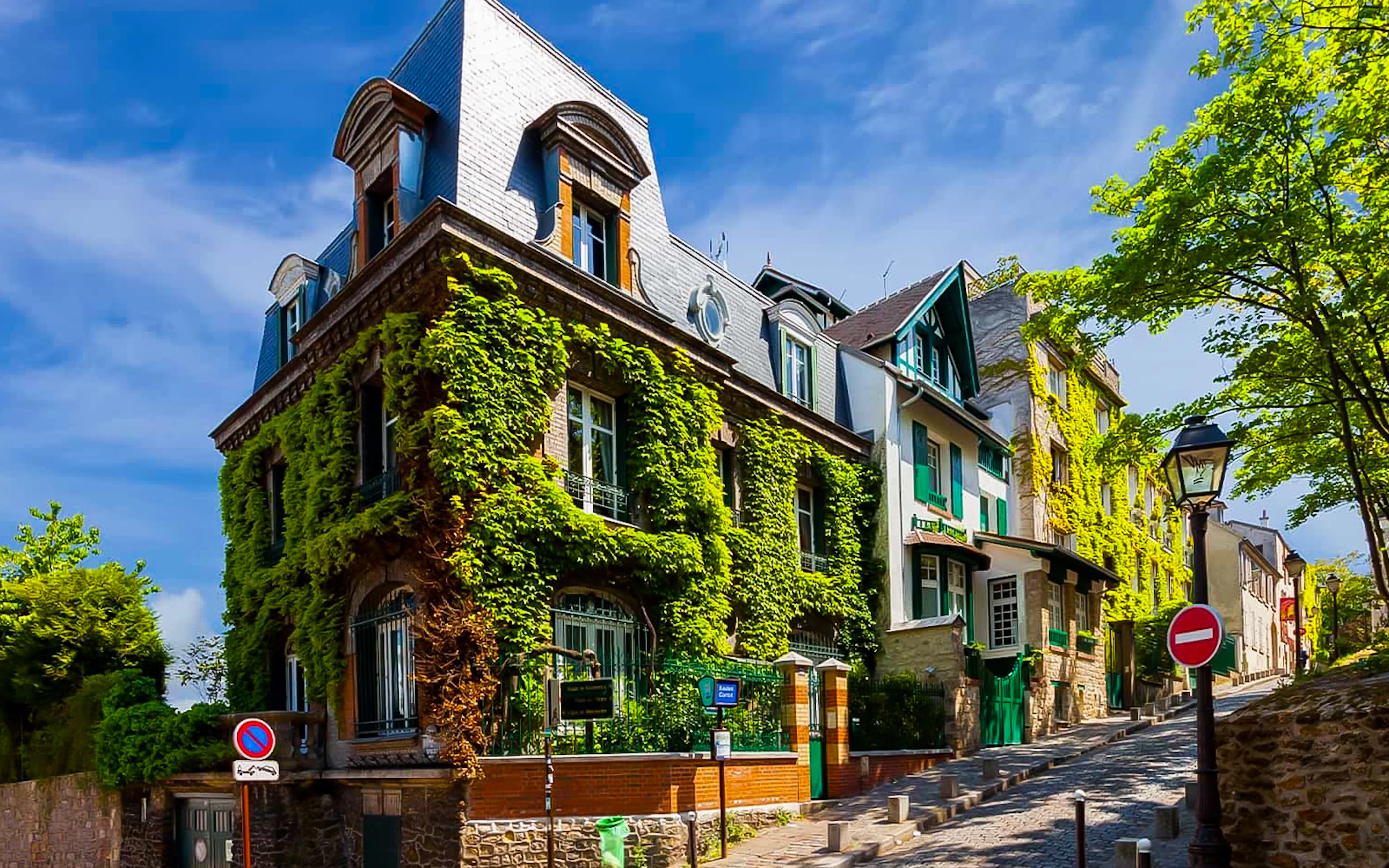 Montmartre street with ivy-covered buildings, part of a romantic walking tour in Paris.