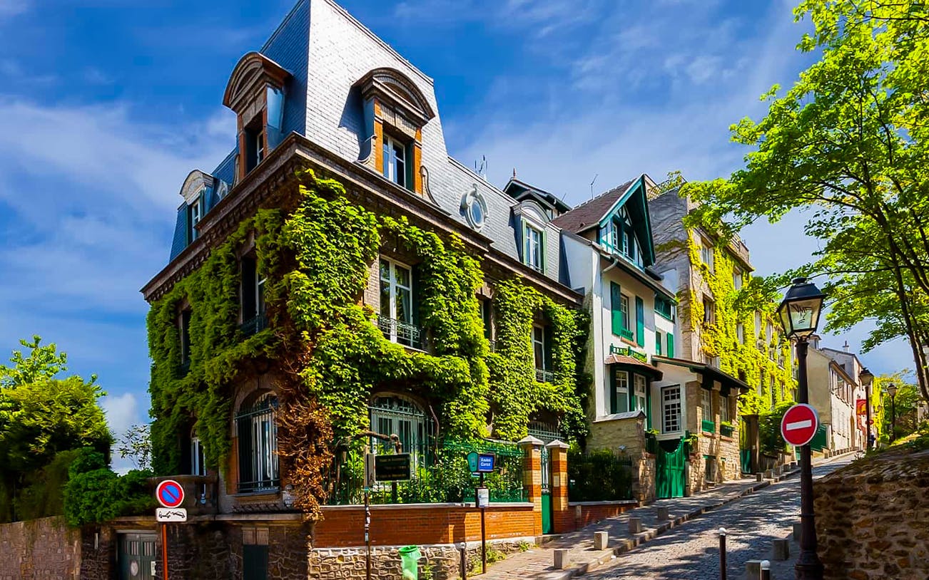 Montmartre street with ivy-covered buildings, part of a romantic walking tour in Paris.
