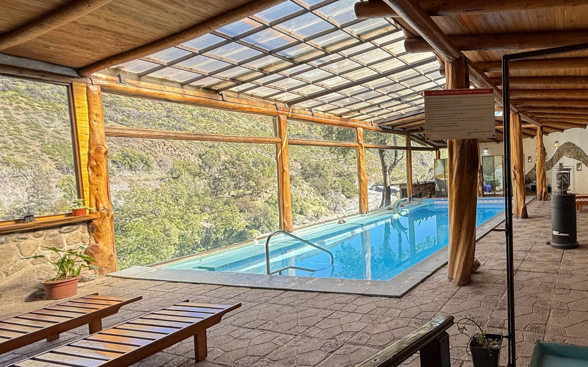Indoor heated pool area with mountain views at Santuario del Río spa and lodge.