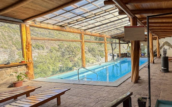 Indoor heated pool area with mountain views at Santuario del Río spa and lodge.
