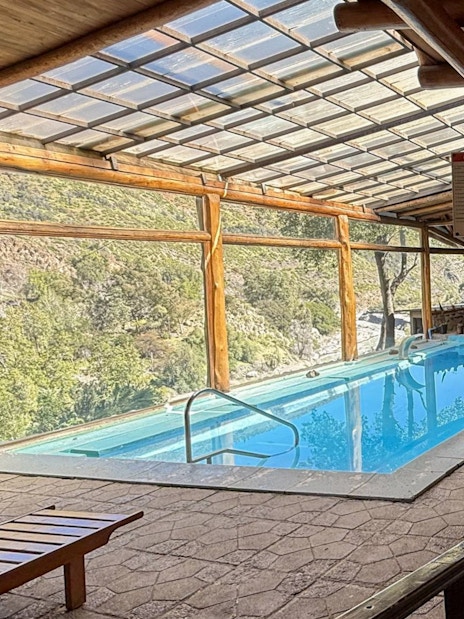 Indoor heated pool area with mountain views at Santuario del Río spa and lodge.