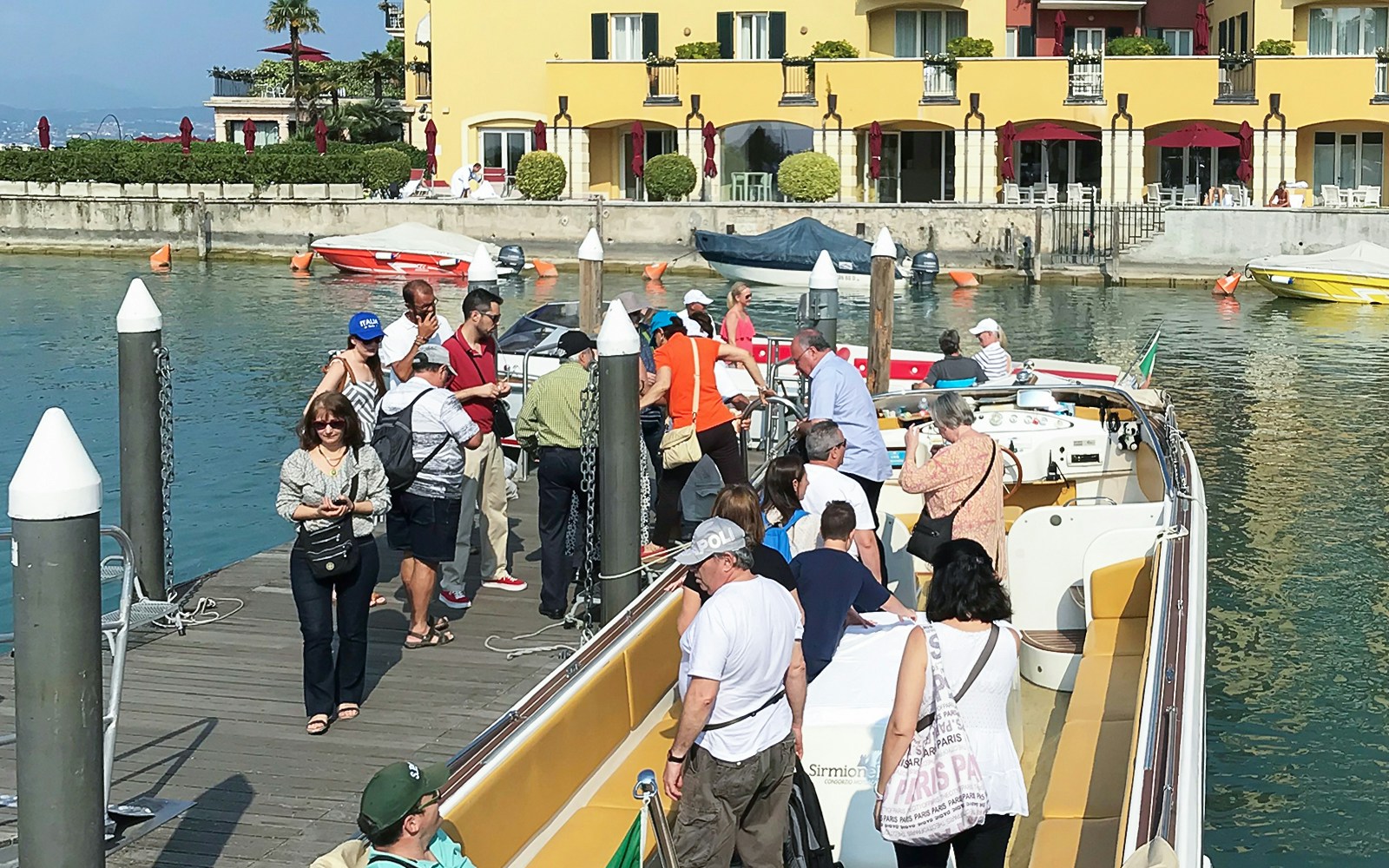 Tourists boarding a boat for a guided full-day tour of Lake Garda.