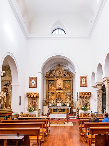 Interior of El Salvador Church in Toledo with altar and religious statues.