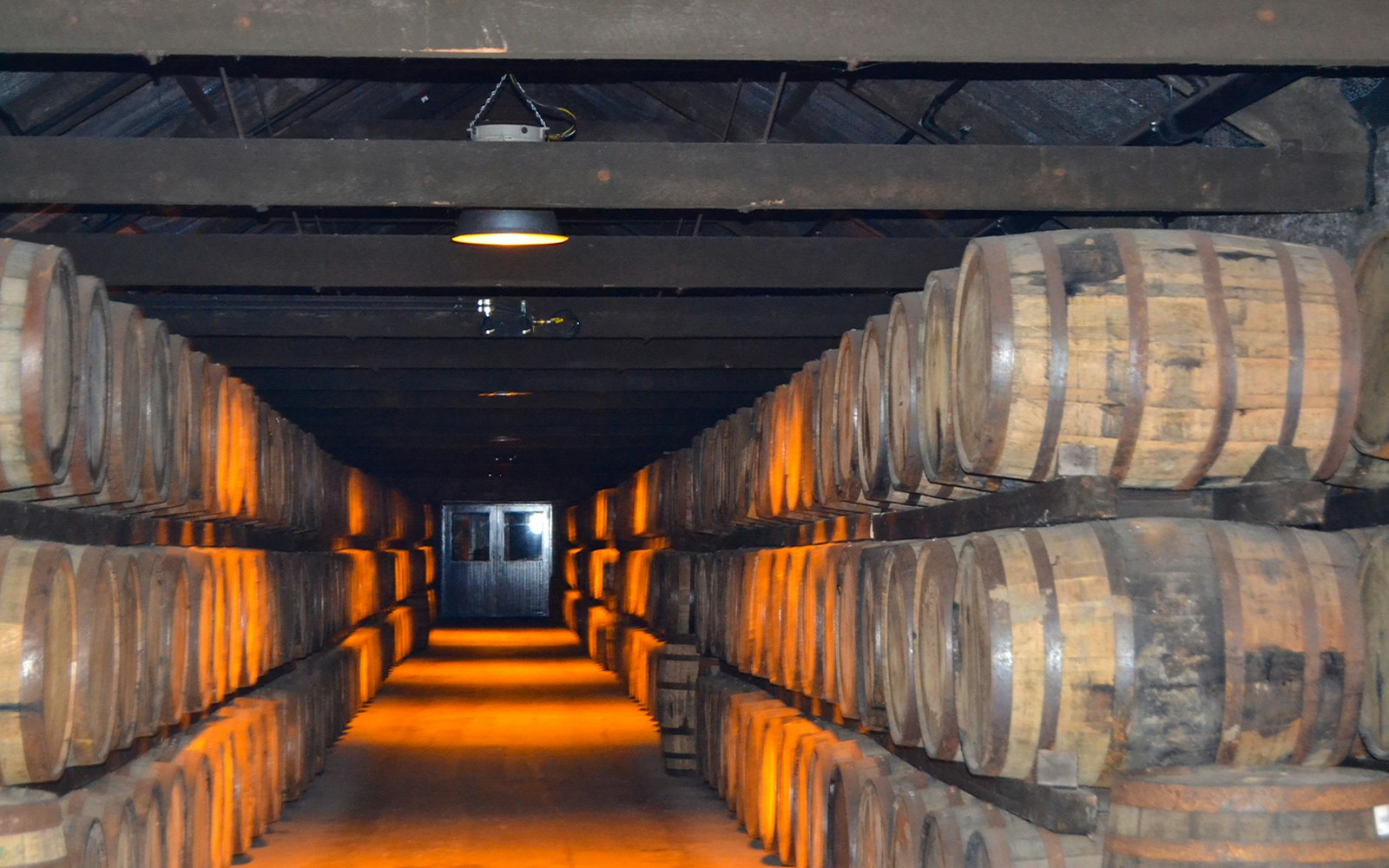 Barrels of Jameson whiskey aging in a dimly lit warehouse.