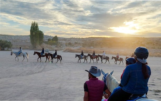 Guests on horseback during sunrise tour in Cappadocia, Turkey.