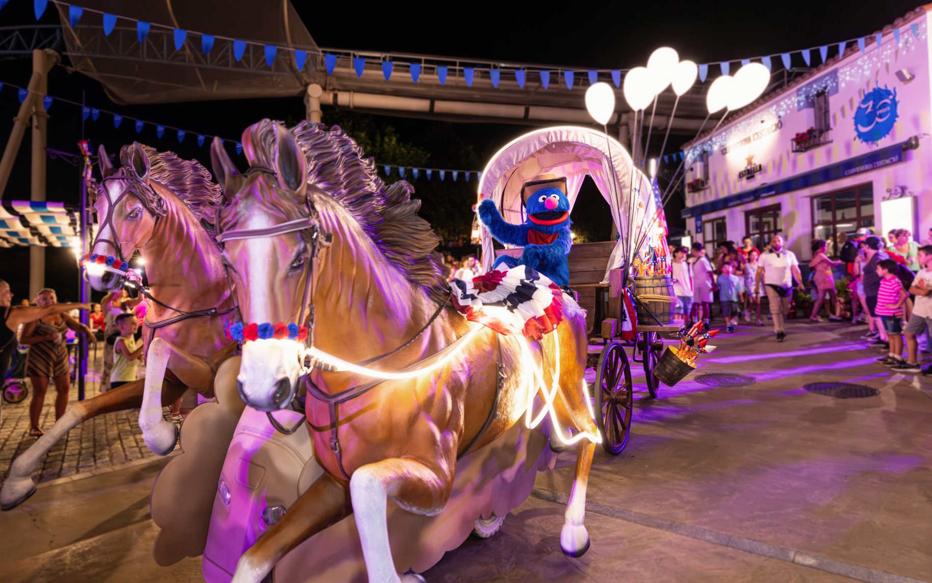 Character in a parade float with horses at PortAventura World birthday celebration.