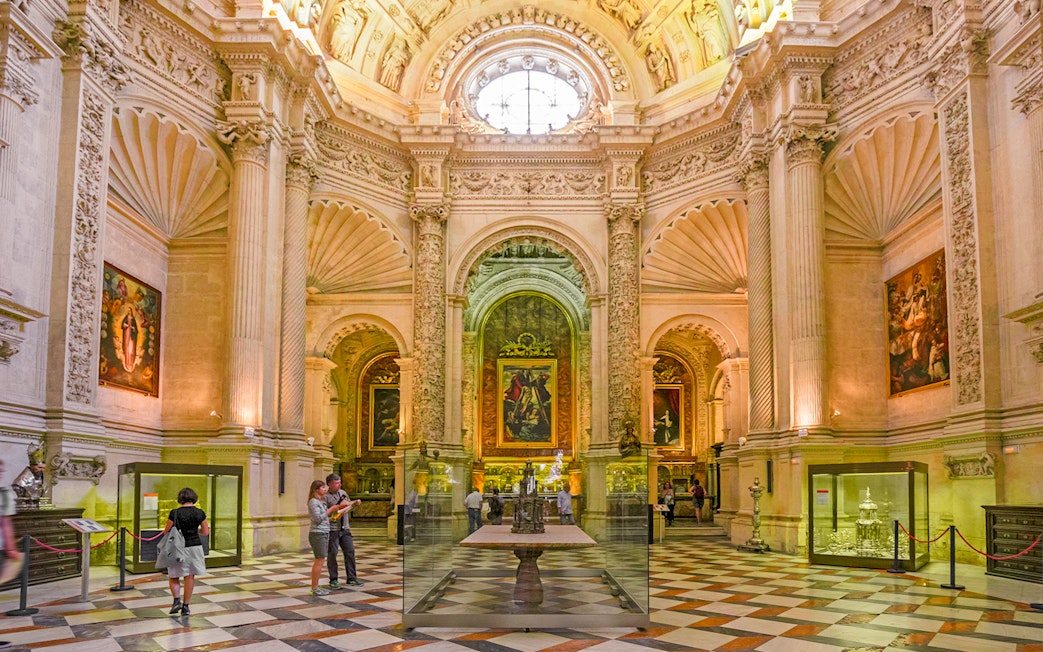 Royal chapel interior with ornate columns and religious paintings, Seville Cathedral, Spain.