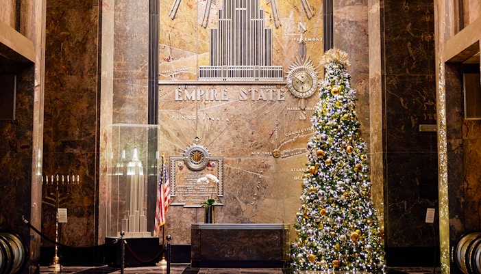 Empire State Building interior with Christmas decorations and festive lights.