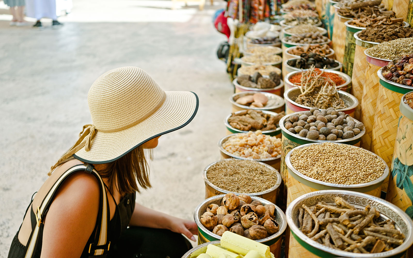 Young woman browsing spice stalls at a traditional market in Dubai.