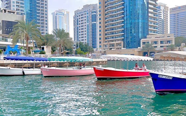 Duffy boats by Love Boats cruising in Dubai Marina with skyscrapers in the background.