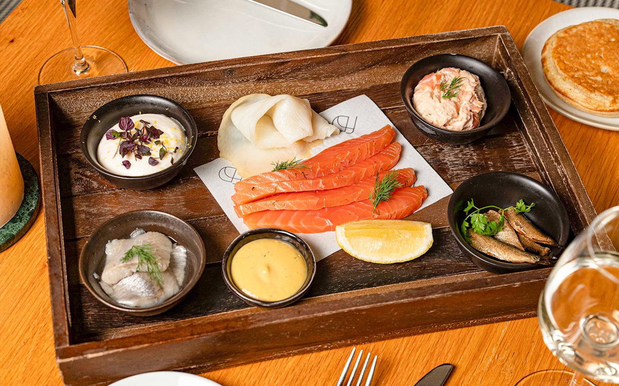 Assorted seafood platter with salmon, herring, and sauces at Flora Danica, Champs Elysées, Paris.